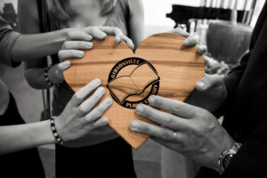 hands holding wood heart with book image